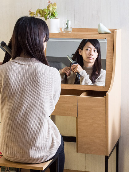 ドレッサーに座ってヘアアレンジをする